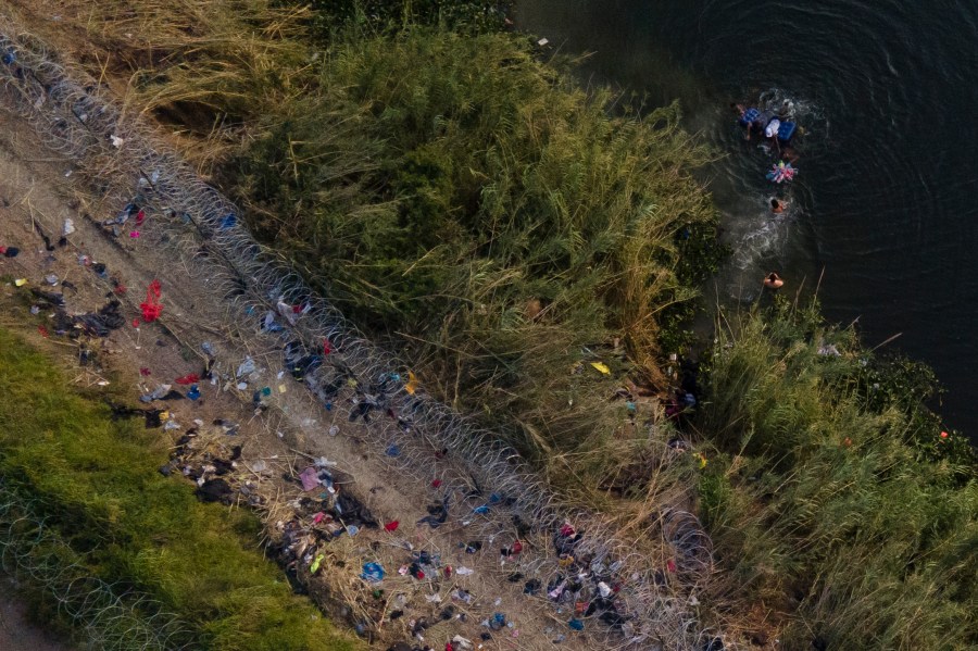 Migrants use a raft to cross the Rio Grande at the Texas-Mexico border, Thursday, May 11, 2023, in Brownsville, Texas.