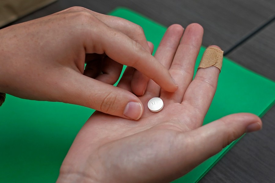 FILE - A patient prepares to take the first of two combination pills, mifepristone, for a medication abortion during a visit to a clinic in Kansas City, Kan., on Wednesday, Oct. 12, 2022. (AP Photo/Charlie Riedel, File)