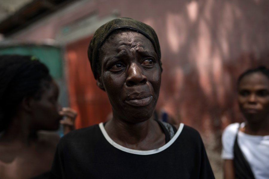 Dieu Frisdeline, who has sought refuge in Jean-Kere Almicar's front yard, cries as she tells how she was raped by gang members, in Port-au-Prince, Haiti, Sunday, June 4, 2023. Nearly 200 people who once lived in the Cite Soleil slum near Almicar’s house are now camped out in his front yard and nearby areas. They are among the nearly 165,000 Haitians who have fled their homes amid a surge in gang violence. (AP Photo/Ariana Cubillos)