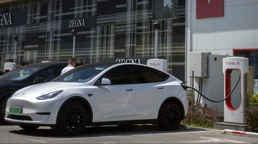 A driver gets into his car at an electric vehicle charging station outside of a Tesla dealership in Beijing, Saturday, June 24, 2023. Threatened by possible shortages of lithium for electric car batteries, automakers are racing to lock in supplies of the once-obscure "white gold" in a politically and environmentally fraught competition from China to Nevada to Chile. (AP Photo/Mark Schiefelbein)