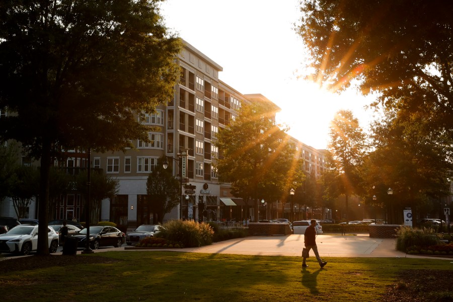 A pedestrian walks through Town Brookhaven, a mixed-use residential and shopping complex, on Wednesday, June 28, 2023, in Brookhaven, Ga. Brookhaven added new parcels in late 2019, but the 1,200 residents who came with the annexation weren't included in the 2020 census. The city of more than 57,000 people in metro Atlanta was among scores of cities, states and tribes that challenged their numbers from the census. (AP Photo/Alex Slitz)