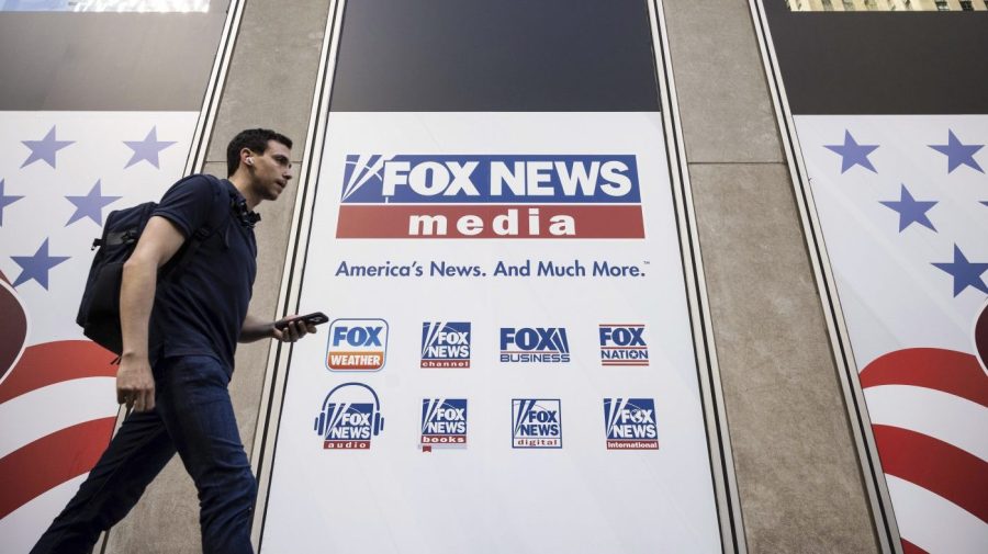 FILE - A person walks past the Fox News Headquarters in New York on April 12, 2023. Fox News will pay one of its former producers $12 million to settle her claims that she faced a discriminatory workplace and that the network tried to coerce her into giving false testimony in Dominion Inc.’s defamation lawsuit against the network, her lawyer said Friday, June 30, 2023.