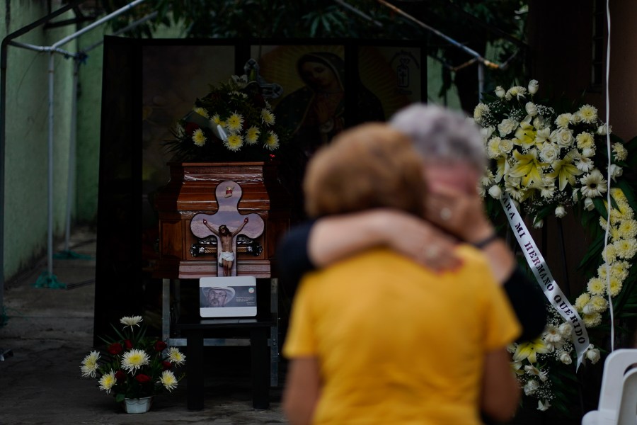 Relatives of Hipolito Mora hug near his casket as a wake is held for the armed civilian defense leader at his home in La Ruana, Mexico, Friday, June 30, 2023. Mora, the leader of an armed civilian movement that once drove a drug cartel out of the western state of Michoacan, was killed Thursday on a street in his hometown.