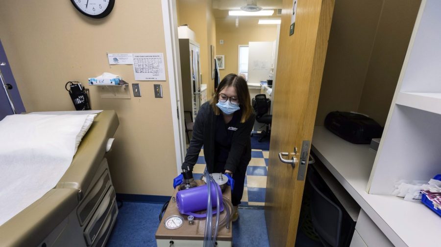 FILE - Lab assistant Sydni Hanson transports a suction machine into a patient room, Thursday, July 7, 2022, at WE Health Clinic in Duluth, Minn. Minnesota recorded a 20% jump in abortions in 2022, partly because more patients are traveling from states that have banned or limited the procedure since the U.S. Supreme Court overturned Roe v. Wade, according to an annual report released Friday, June 30, 2023. (AP Photo/Derek Montgomery, File)