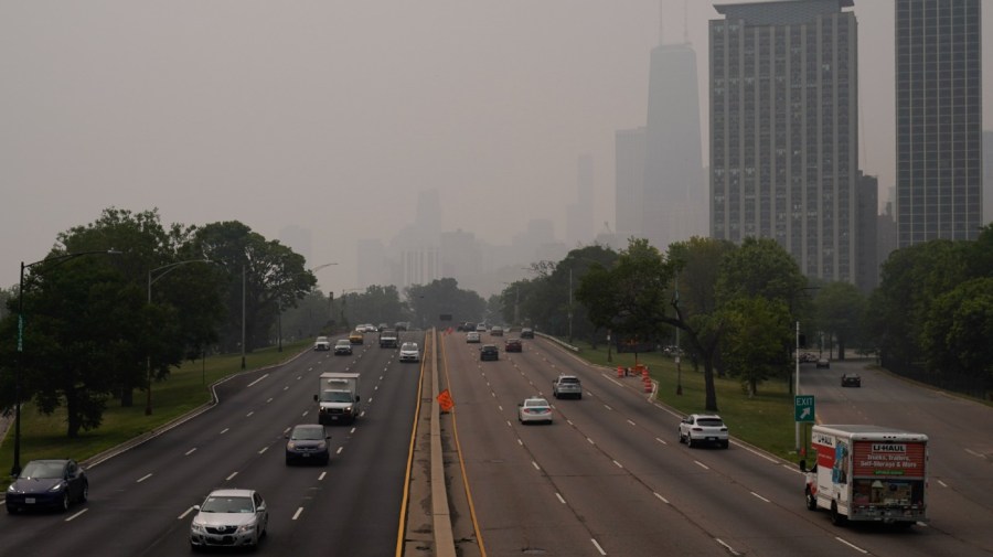 Cars pass through Lake Shore Drive as the downtown skyline is blanketed in haze from Canadian wildfires Tuesday, June 27, 2023, in Chicago.