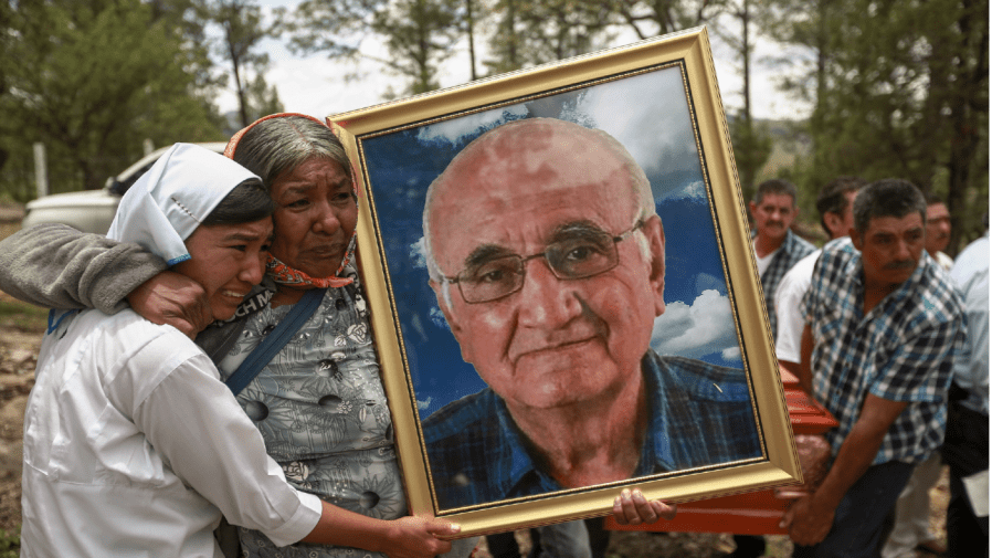 Women hold a portrait of Jesuit priest Javier Campos Morales as his funeral procession and that of fellow priest Joaquin Cesar Mora Salazar arrives to Cerocahui, Chihuahua state, Mexico, Sunday, June 26, 2022, after the the two elderly priests and a tour guide were murdered in Mexico's Sierra Tarahumara. The Jesuits said on Wednesday, February 1, 2023, that they have decided to reinforce Cerocahui with three more priests. (AP Photo/Christian Chavez, File)