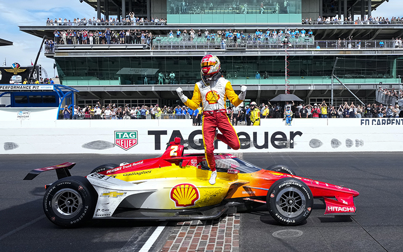 Josef Newgarden stands on his care at the finish line after winning the Indianapolis 500