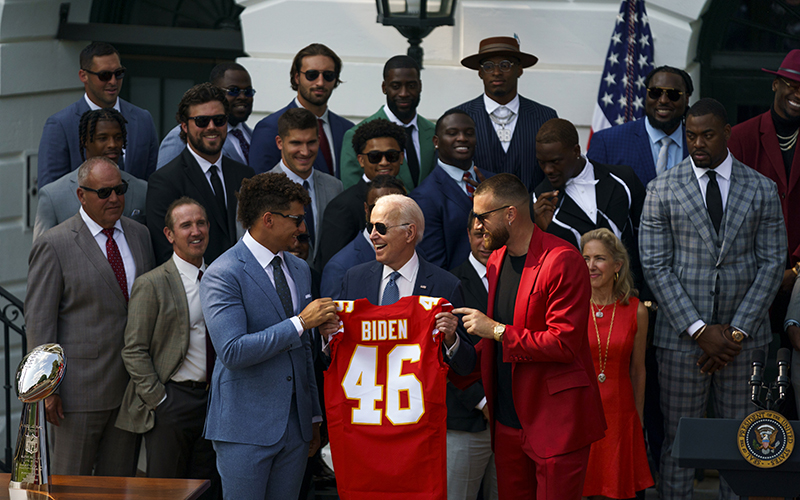 Kansas City Chiefs quarterback Patrick Mahomes and tight end Travis Kelce present President Biden with a red team jersey displaying his name