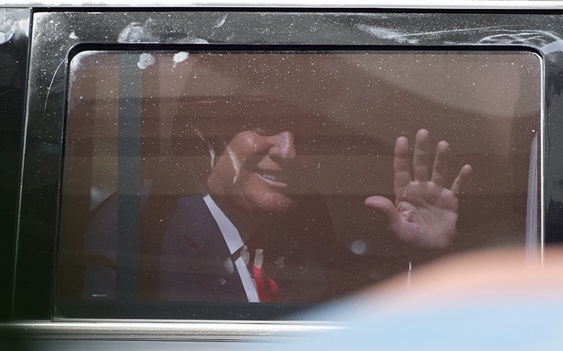 Former President Trump is seen waving through the window of his SUV