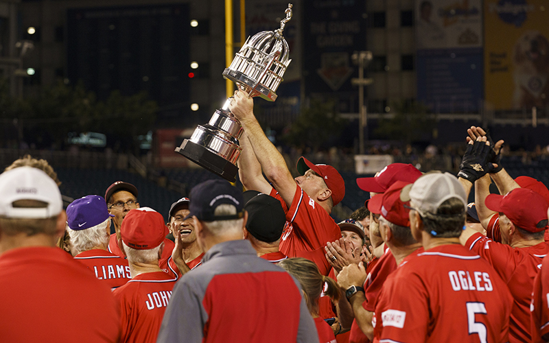 Surrounded by his team in red shirts, Sen. Eric Schmitt (R-Mo.) lifts the trophy after beating the Democrats 16-6 in the Congressional Baseball Game