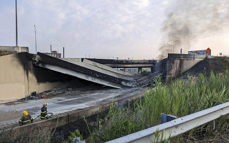 Firefighters stand near the collapsed part of I-95 in Philadelphia