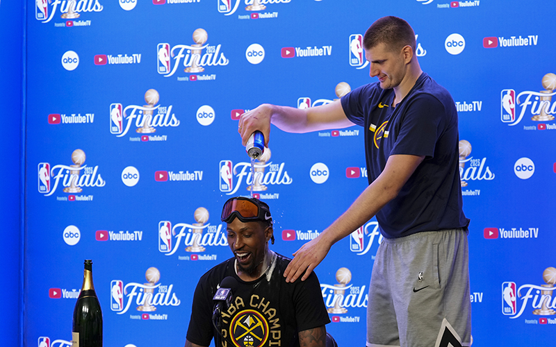 Denver Nuggets star Nikola Jokic, right, pours beer on Kentavious Caldwell-Pope during a news conference