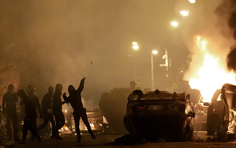 Flipped cars and flames are seen as youths clash with police forces in Nanterre, France