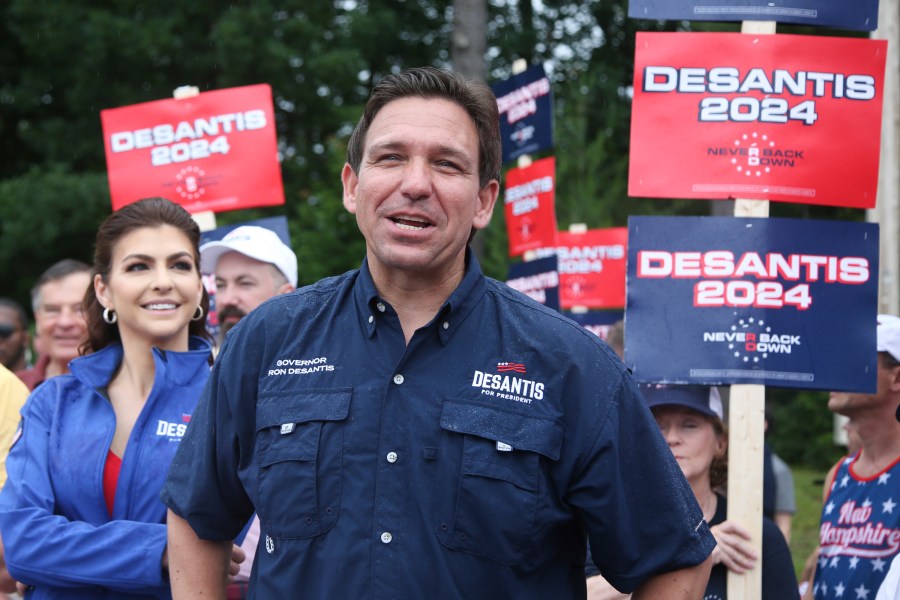 FILE - Republican presidential candidate and Florida Gov. Ron DeSantis and his wife Casey, walk in the July 4th parade, July 4, 2023, in Merrimack, N.H. DeSantis is defending an anti-LGBTQ video his campaign shared online that attacks rival Donald Trump for his past support of gay and transgender people, despite some of his fellow Republicans calling it homophobic. (AP Photo/Reba Saldanha, File)