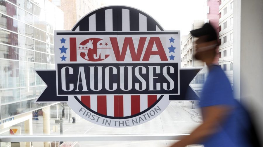 FILE - A pedestrian walks past a sign for the Iowa Caucuses on a downtown skywalk, in Des Moines, Iowa, on Feb. 4, 2020. Iowa Republicans have scheduled the party’s presidential nominating caucuses for Jan. 15, 2024, putting the first votes of the next election a little more than six months away. (AP Photo/Charlie Neibergall, File)