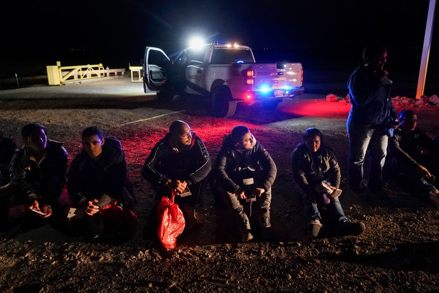 FILE - Migrants wait to be processed after crossing the border, Jan. 6, 2023, near Yuma, Ariz. A judge will hear arguments Wednesday, July 19, in a lawsuit opposing an asylum rule that has become a key part of the Biden administration’s immigration policy. Critics say the rule endangers migrants trying to cross the southern border and is against the law, while the administration argues that it encourages migrants to use lawful pathways into the country and prevents chaos at the border. (AP Photo/Gregory Bull, File)