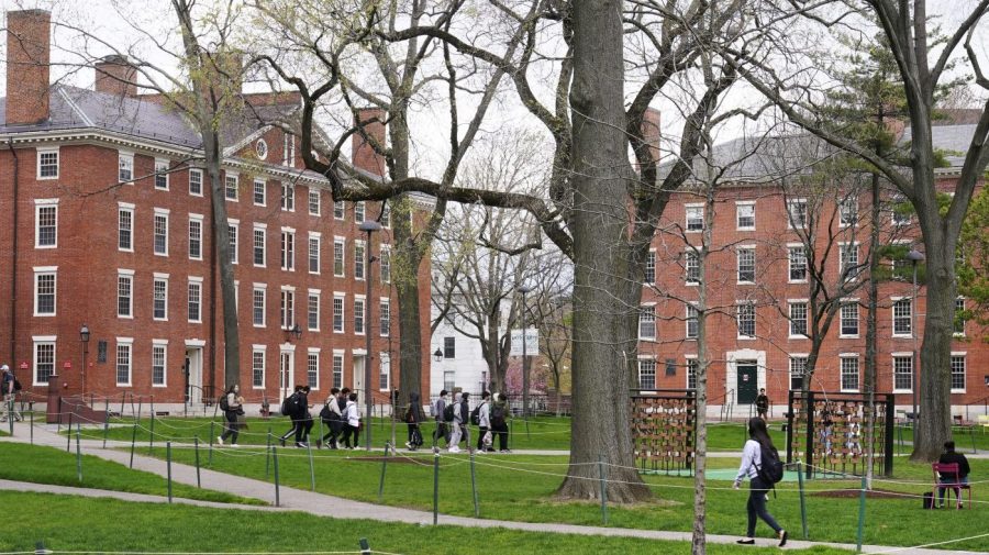 FILE - Students walk through Harvard Yard, April 27, 2022, on the campus of Harvard University in Cambridge, Mass. On Monday, July 24, 2023, the U.S. Department of Education opened an investigation into Harvard University's policies on legacy admissions, which give an edge to applicants with family ties to alumni. (AP Photo/Charles Krupa, File)