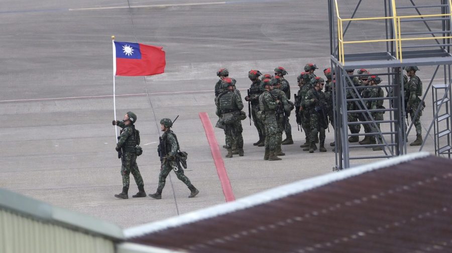 A soldier holds a Taiwan national flag during military exercises at Taoyuan International Airport in Taoyuan, Northern Taiwan, Wednesday, July 26, 2023.