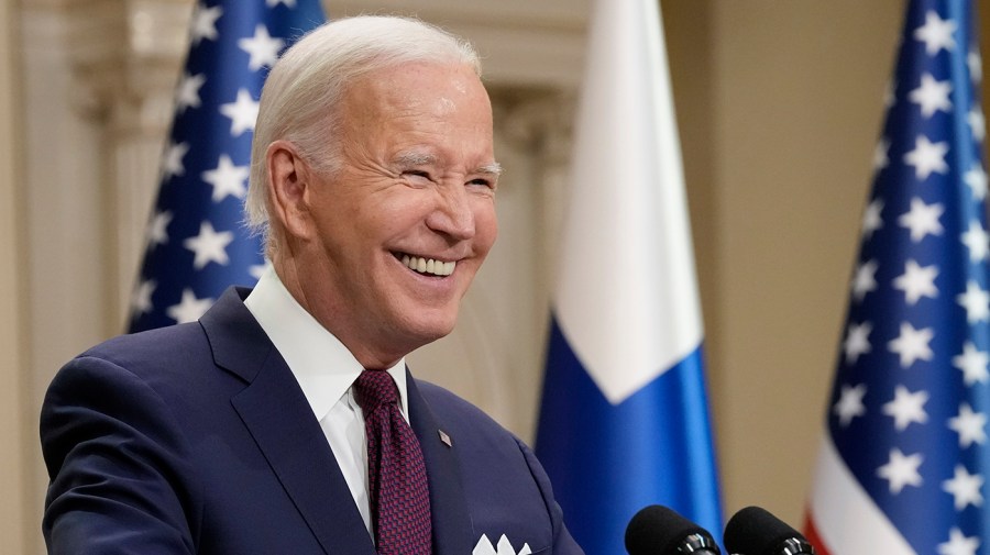 President Joe Biden smiles during a news conference.