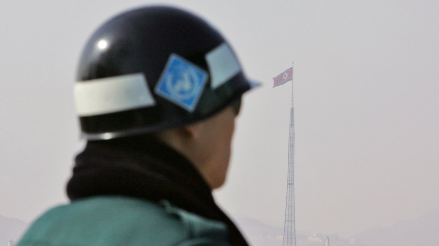 A South Korean soldier looks at a North Korean flag at the border village of Panmunjom in the demilitarized zone (DMZ) that separates the two Koreas since the Korean War, South Korea, Wednesday, Feb. 20, 2008. (AP Photo/Ahn Young-joon)