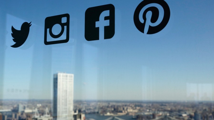 Icons for Twitter, Instagram, Facebook and Pinterest are displayed on a window, Wednesday, Jan. 13, 2016, in New York. (AP Photo/Mark Lennihan)