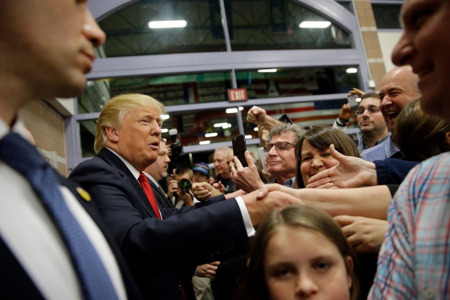 FILE - Republican presidential candidate Donald Trump, left, greets supporters at a caucus site, Feb. 23, 2016, in Las Vegas. (AP Photo/Jae C. Hong, File)