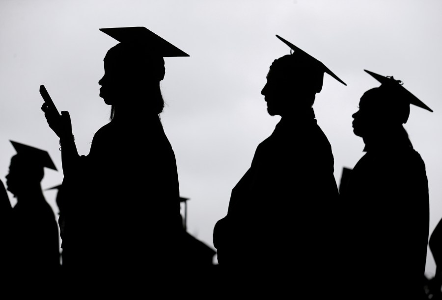 FILE - New graduates line up before the start of a community college commencement in East Rutherford, N.J., May 17, 2018. This summer, millions of Americans with student loans will be able to apply for a new repayment plan that offers some of the most lenient terms ever. Interest won’t pile up as long as borrowers make regular payments. Millions of people will have payments of $0. And starting in 2024, undergraduate loan payments will be reduced by half. (AP Photo/Seth Wenig, File)