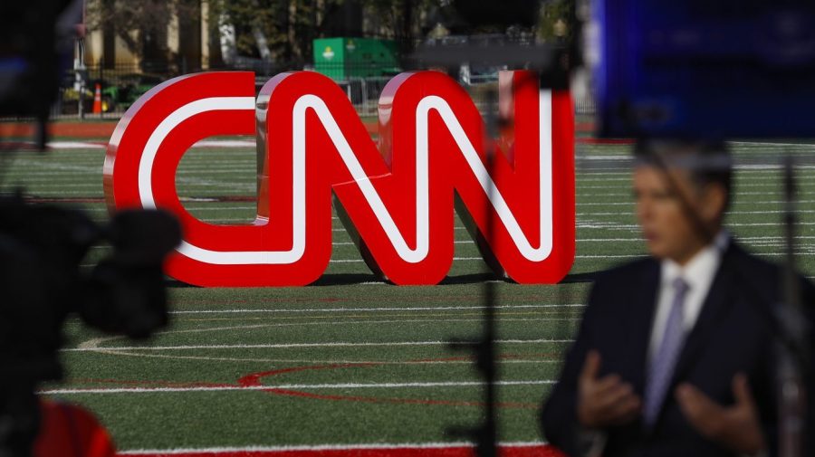 FILE - A journalist records video near a CNN sign on an athletic field outside the Clements Recreation Center where the CNN/New York Times will host the Democratic presidential primary debate at Otterbein University, Monday, Oct. 14, 2019, in Westerville, Ohio. Mark Thompson was appointed as chair and CEO of CNN by David Zaslav, head of the network's parent company, Warner Bros. Discovery, which made the announcement Wednesday, Aug. 30, 2023. Thompson replaces Chris Licht, who was fired in June, and a four-person team that had been running CNN in the interim. (AP Photo/John Minchillo, File)