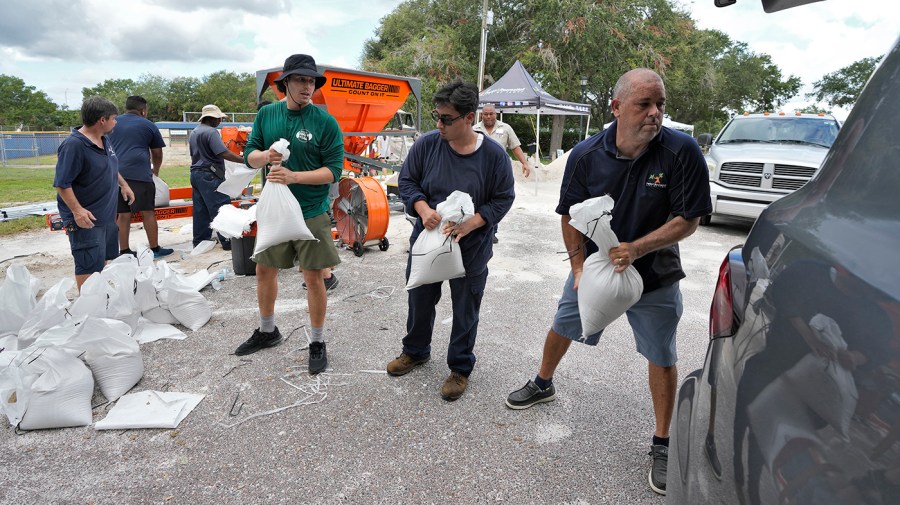 Members of the Tampa, Fla., Parks and Recreation Dept., help residents load sandbags Monday, Aug. 28, 2023, in Tampa, Fla. Residents along Florida's gulf coast are making preparations for the effects of Hurricane Idalia.