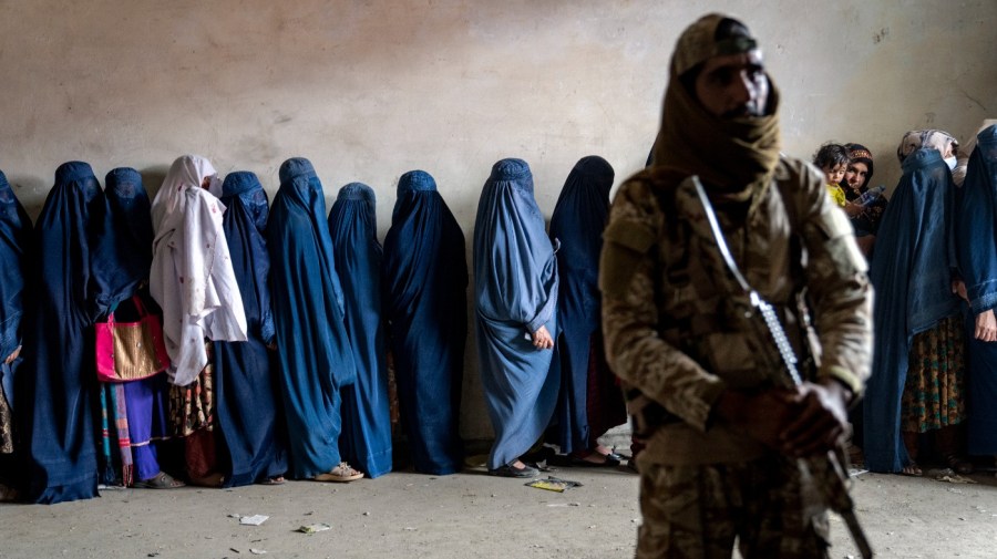 A Taliban fighter stands guard as women wait to receive food rations distributed by a humanitarian aid group in Kabul, Afghanistan, Tuesday, May 23, 2023. (AP Photo/Ebrahim Noroozi, File)