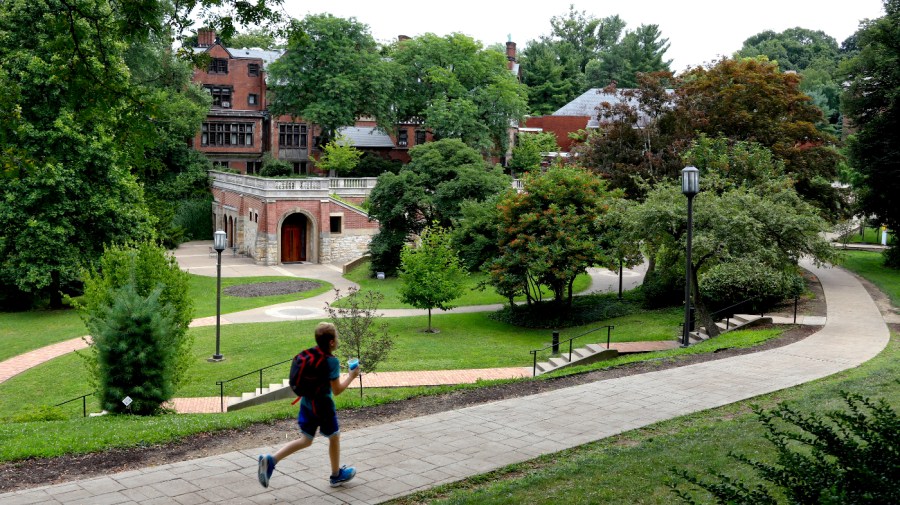 A student walks a path near Mellon Hall, rear, on the campus of Chatham University in Pittsburgh.