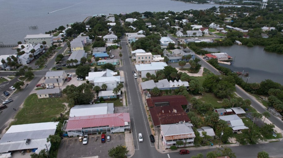 File - In this photo taken with a drone, businesses are seen along 2nd Street in Cedar Key, Fla., ahead of the expected arrival of Hurricane Idalia, Tuesday, Aug. 29, 2023. Several local residents said they planned to ride out the storm at the Cedar Inn Motel, with red roof, lower left.