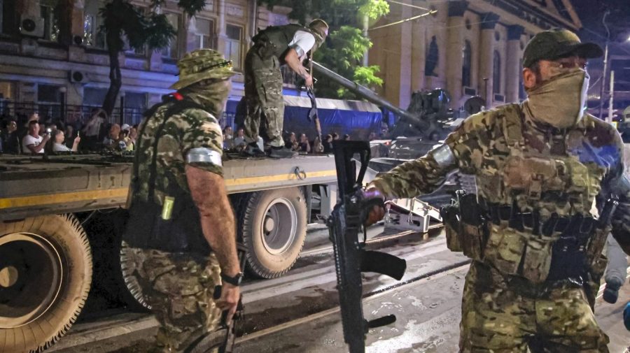 FILE - Members of the Wagner Group military company guard an area as other load their tank onto a truck on a street in Rostov-on-Don, Russia, Saturday, June 24, 2023, prior to leaving an area at the headquarters of the Southern Military District. The U.K. says it will declare Russia’s Wagner mercenary group a banned terrorist organization. British officials say the group remains a threat to global security even after the death of leader Yevgeny Prigozhin. (Vasily Deryugin, Kommersant Publishing House via AP, File)