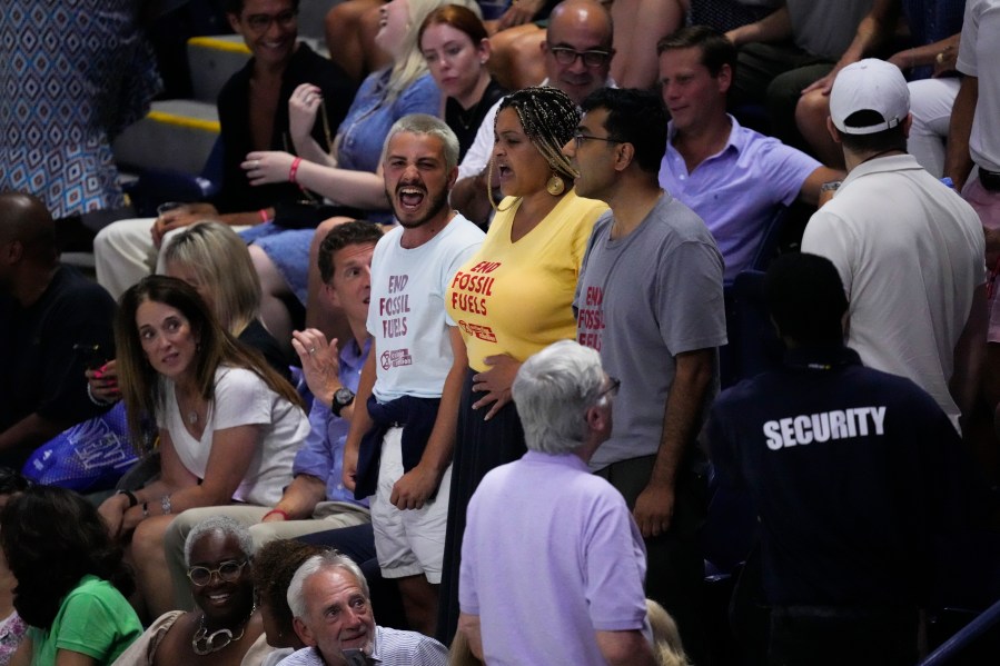 Protesters demonstrate at a match between Coco Gauff, of the United States, and Karolina Muchova, of the Czech Republic, during the women's singles semifinals of the U.S. Open tennis championships, Thursday, Sept. 7, 2023, in New York. (AP Photo/John Minchillo)