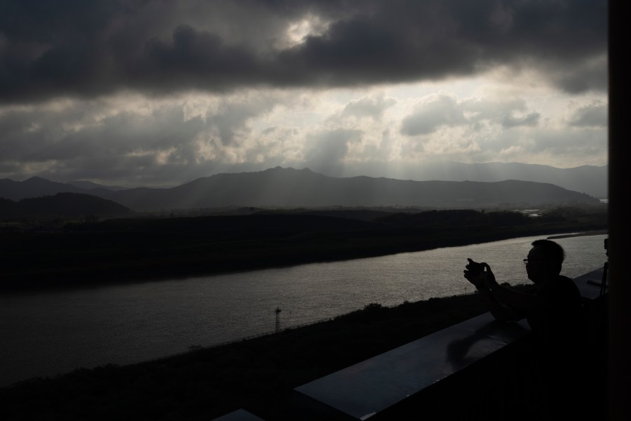 A visitor to the Yiyanwang Three Kingdoms viewing platform looks over into the North Korean border across from Fangchuan in northeastern China's Jilin province on Monday, Sept. 11, 2023. Russia and North Korea confirmed Monday that North Korean leader Kim Jong Un will visit Russia in a highly anticipated meeting with President Vladimir Putin that has sparked Western concerns about a potential arms deal for Moscow's war in Ukraine. (AP Photo/Ng Han Guan)