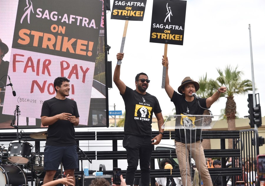 Kal Penn, center, and John Cho, right, speak during a rally outside Paramount Pictures Studio on Wednesday, Sept. 13, 2023, in Los Angeles. The film and television industries remain paralyzed by Hollywood's dual actors and screenwriters strikes. (Photo by Richard Shotwell/Invision/AP)