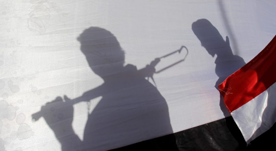 FILE - The shadow of Shiite rebels, known as Houthis, are cast on a large representation of the Yemeni flag as they attend a demonstration against an arms embargo imposed by the U.N. Security Council on Houthi leaders, in Sanaa, Yemen, on April 16, 2015. A delegation from Yemen's Houthi rebels have flown into Saudi Arabia for talks with the kingdom on potentially ending the yearslong war tearing at the Arab world's poorest nation, officials say. (AP Photo/Hani Mohammed, File)