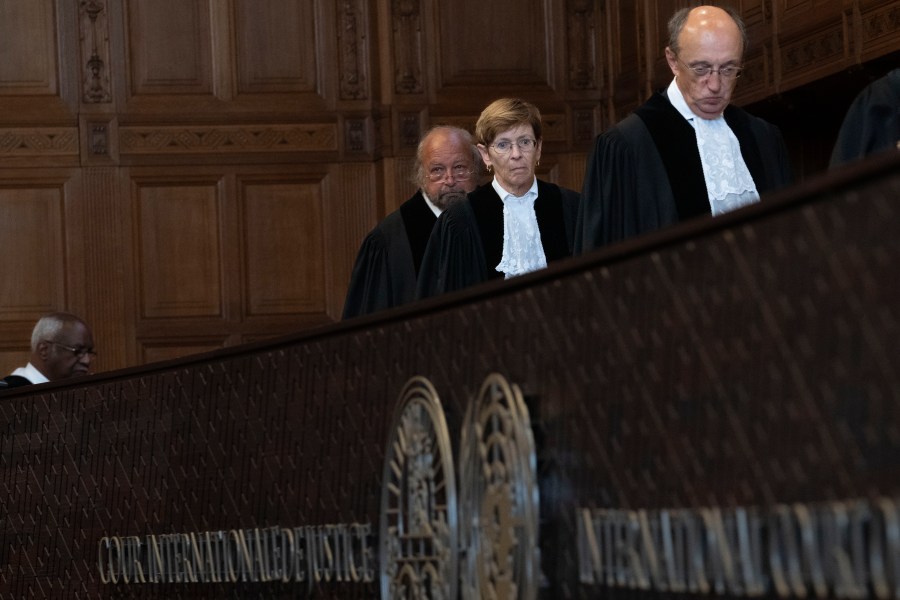 Presiding judge Joan Donoghue, center, follows judge Peter Tomka, right, and is followed by judge Ronny Abraham, left, as they enter the World Court where Ukraine's legal battle against Russia over allegations of genocide used by Moscow to justify its 2022 invasion, resumed in The Hague, Netherlands, Tuesday, Sept. 19, 2023. Russia seeks to have a groundbreaking case tossed out at the International Court of Justice, also known as the Word Court, in a case which will see Ukraine supported by a record 32 other nations in a major show of support for the embattled nation.(AP Photo/Peter Dejong)