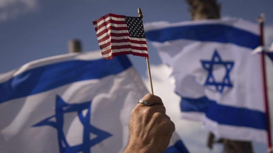 FILE - Israelis opposed to a contentious government plan to overhaul the judiciary wave Israeli and American flags during a protest in support of President Joe Biden, who criticized the plan this week, outside of the U.S. Embassy Branch Office in Tel Aviv, Israel, March 30, 2023. As Biden prepares to meet Israeli Prime Minister Benjamin Netanyahu this week in New York, a new poll finds that while Americans generally view Israel as a partner or ally, many question whether his far-right government shares American values. (AP Photo/Oded Balilty, File)