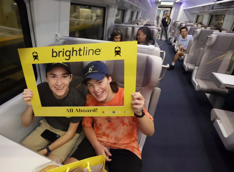 Passengers celebrate as the first Brightline train to Miami for the debut of service from Orlando International Airport pulls out of the station, early Friday, Sept. 22, 2023. The high-speed Orlando-Miami route marks first new privately-owned inter-city passenger service to roll out in the U.S. in 100 years. (Joe Burbank /Orlando Sentinel via AP)