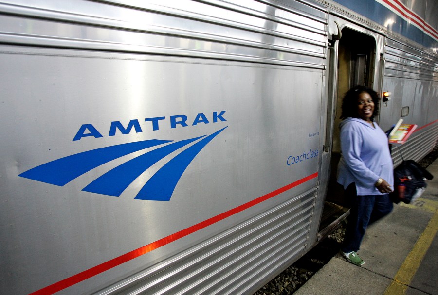 A passenger disembarks an Amtrak train.