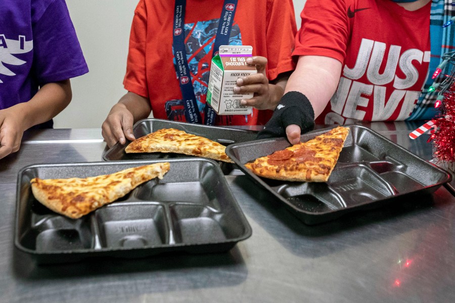 FILE - Second-grade students select their meals during lunch break in the cafeteria, Dec. 12, 2022, at an elementary school in Scottsdale, Ariz. More students in schools serving low-income communities will be eligible to receive breakfast and lunch at no cost under a rule change announced Tuesday, Sept. 26, 2023, by the U.S. Department of Agriculture. (AP Photo/Alberto Mariani, File)