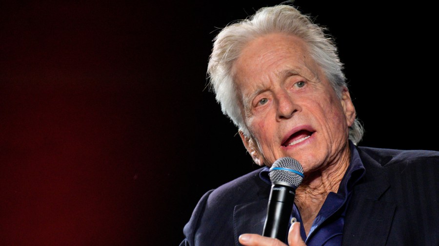 Michael Douglas speaks into a microphone.