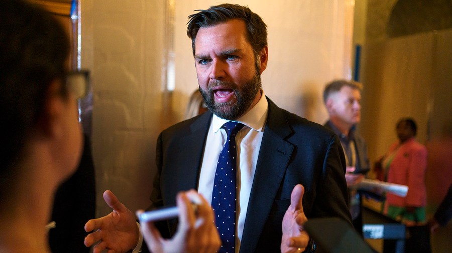 Senator J.D. Vance gestures while speaking to reporters.