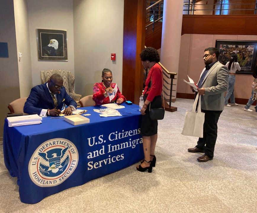 Candidates for U.S. citizenship check in at The Carter Center, Sunday, Oct. 1, 2023, in Atlanta, for their naturalization ceremony. The event included 99 new citizens to mark former President Jimmy Carter's 99th birthday. The new Americans came from 45 countries. (AP Photo/Bill Barrow)