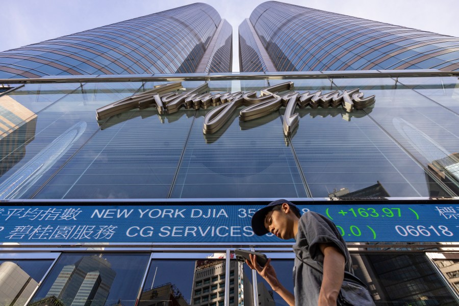 FILE - A pedestrian passes by the Hong Kong Stock Exchange electronic screen in Hong Kong on July 21, 2023. Stocks mostly slipped in mixed trading Monday, Oct. 2, as the constrictor of higher interest rates tightened its coils around Wall Street. (AP Photo/Louise Delmotte, File)