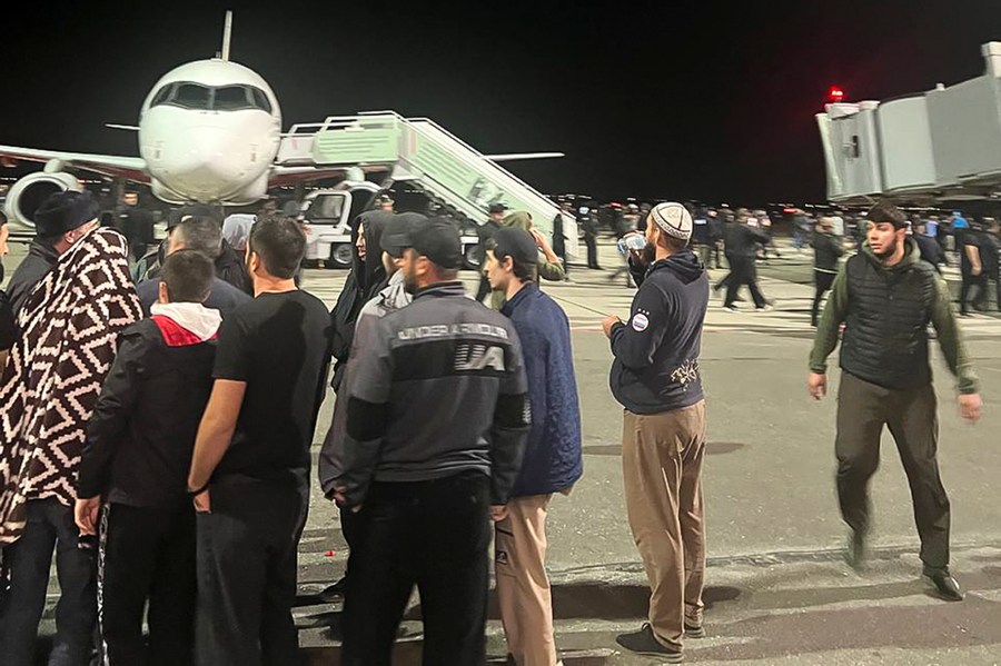 People in the crowd walk shouting antisemitic slogans at an airfield of the airport in Makhachkala, Russia, Monday, Oct. 30, 2023. Russian news agencies and social media say hundreds of people have stormed into the main airport in the Dagestan region and onto the landing field to protest the arrival of an airliner coming from Tel Aviv, Israel. (AP Photo)