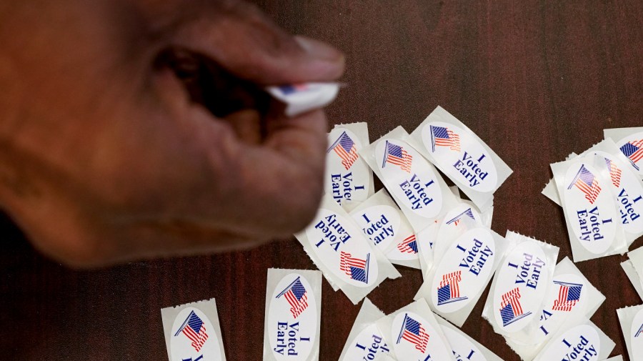 A voter takes a sticker after casting an early ballot at a polling station Thursday, Feb. 9, 2023, in Milwaukee.