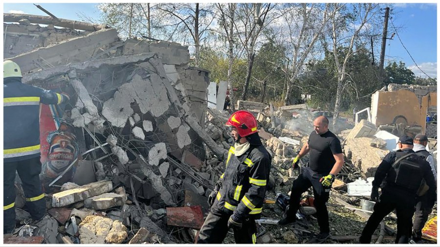 In this photo provided by the Ukrainian Presidential Press Office, emergency workers search the victims of the deadly Russian rocket attack that killed more than people in the village of Hroza near Kharkiv, Ukraine, Thursday, Oct. 5, 2023. (Ukrainian Presidential Press Office via AP)