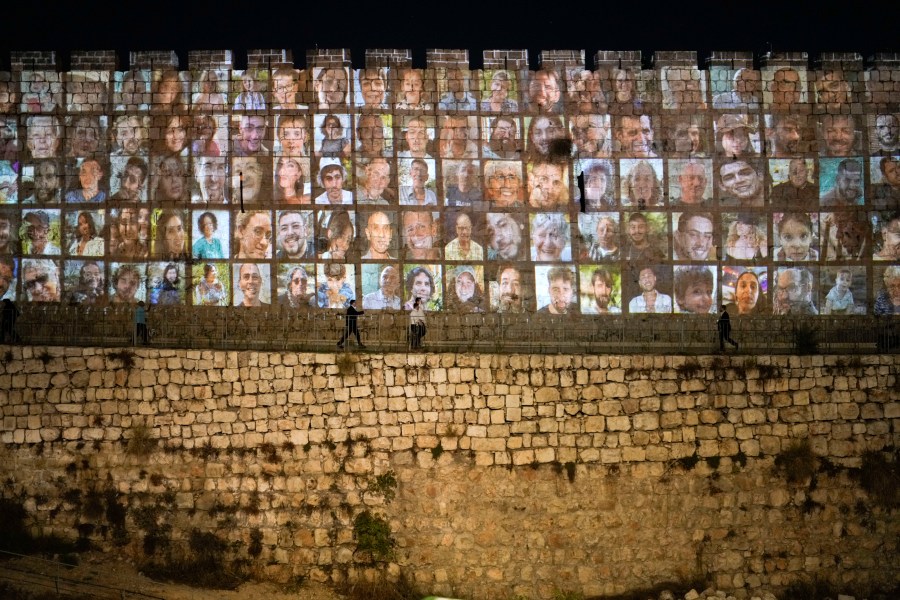 Photographs of Israeli hostages being held by Hamas militants are projected on the walls of Jerusalem's Old City, Monday, Nov. 6, 2023. The Islamic militant group killed 1,400 people and kidnapped 240 others in an unprecedented cross-border attack on Oct. 7, triggering a war that has raged for the past month. (AP Photo/Leo Correa)